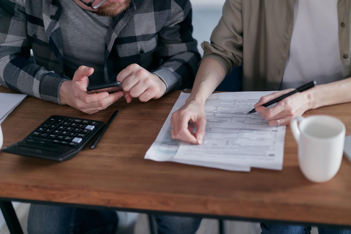 Deux personnes vérifient des factures et des documents comptables